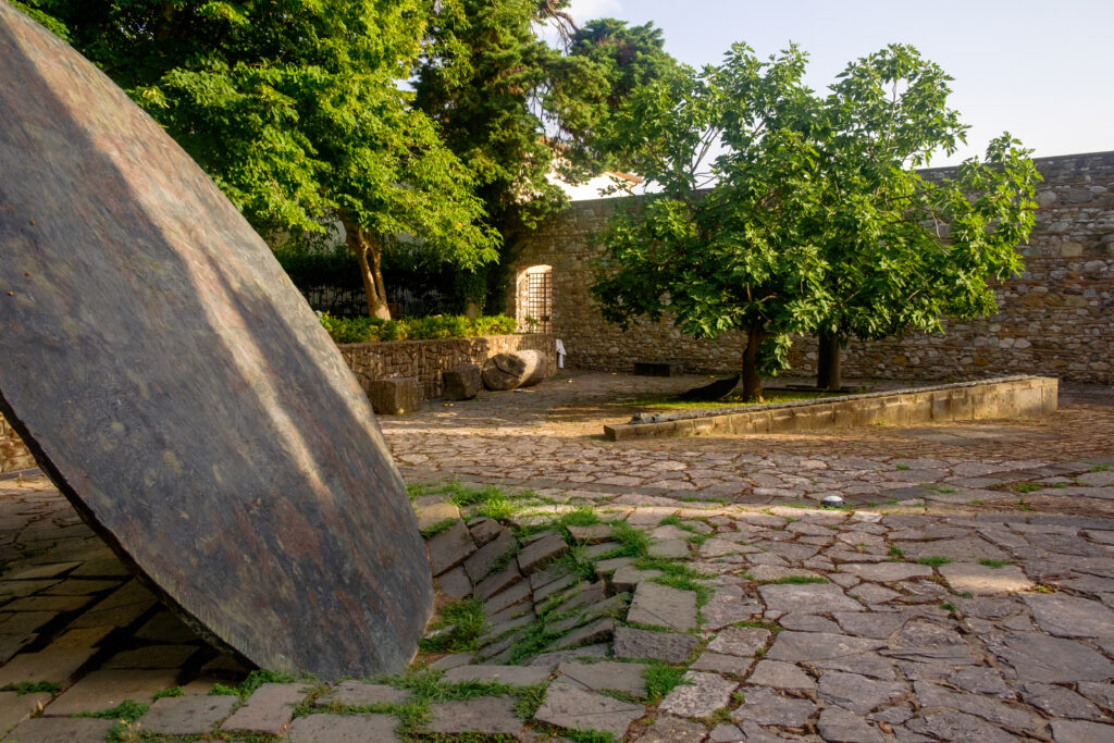 Hortus Conclusus in Benevento with its big metallic disk sculpture purposely crashed in the ground.